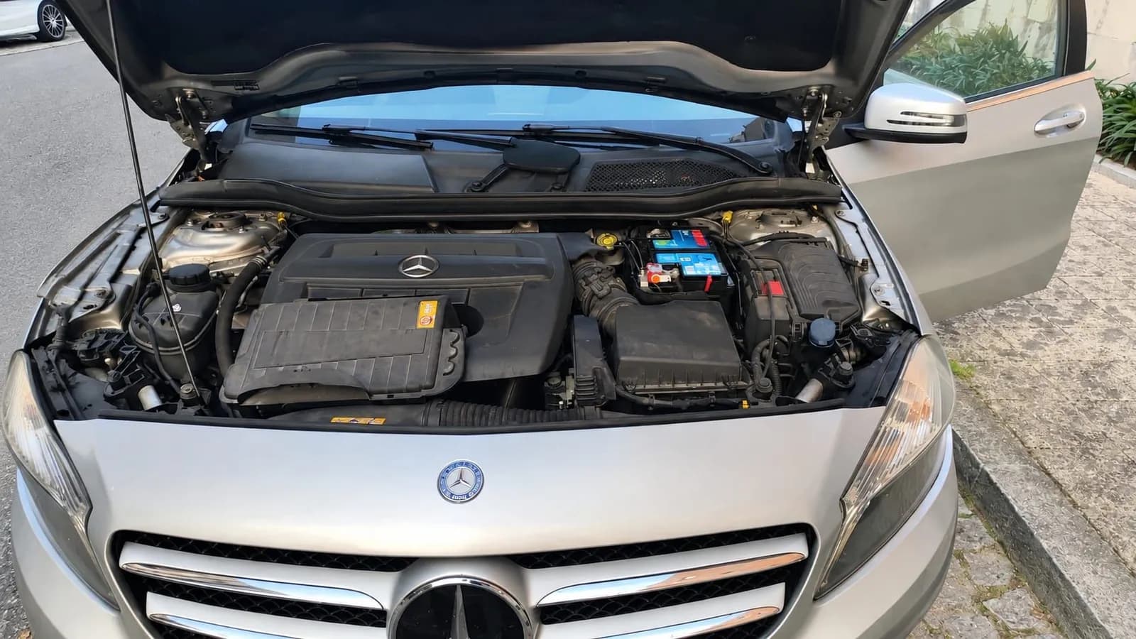 Mercedes with the bonnet open during a battery service